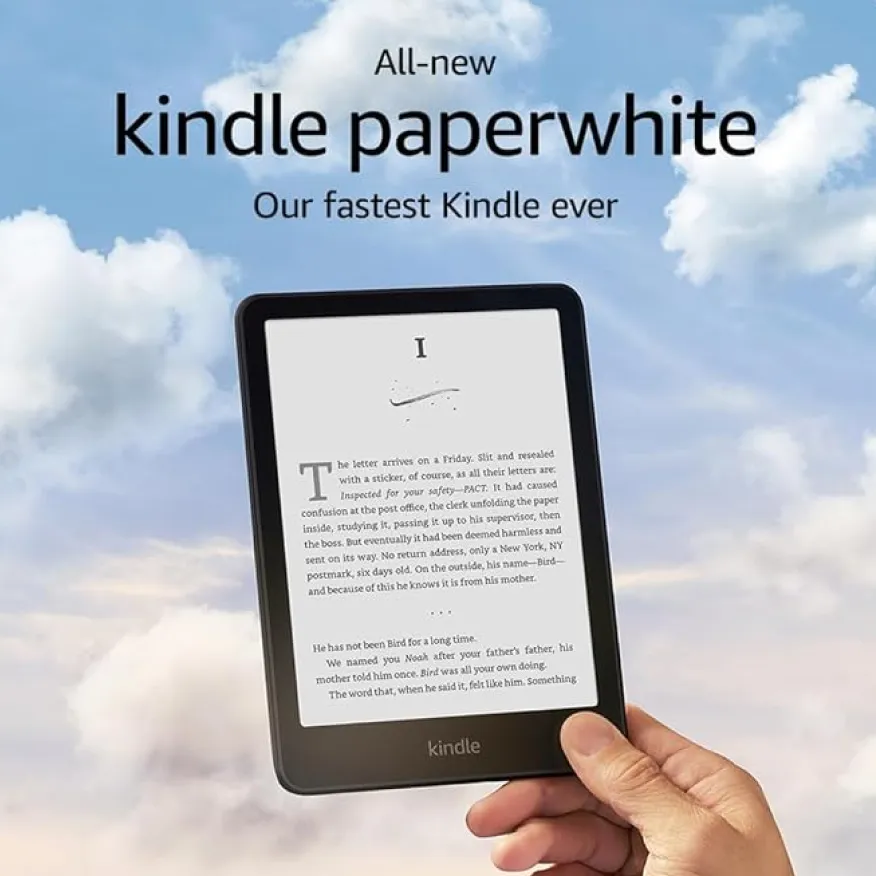 Hand holding an all-new Kindle Paperwhite e-reader displaying text, with a background of blue sky and clouds.