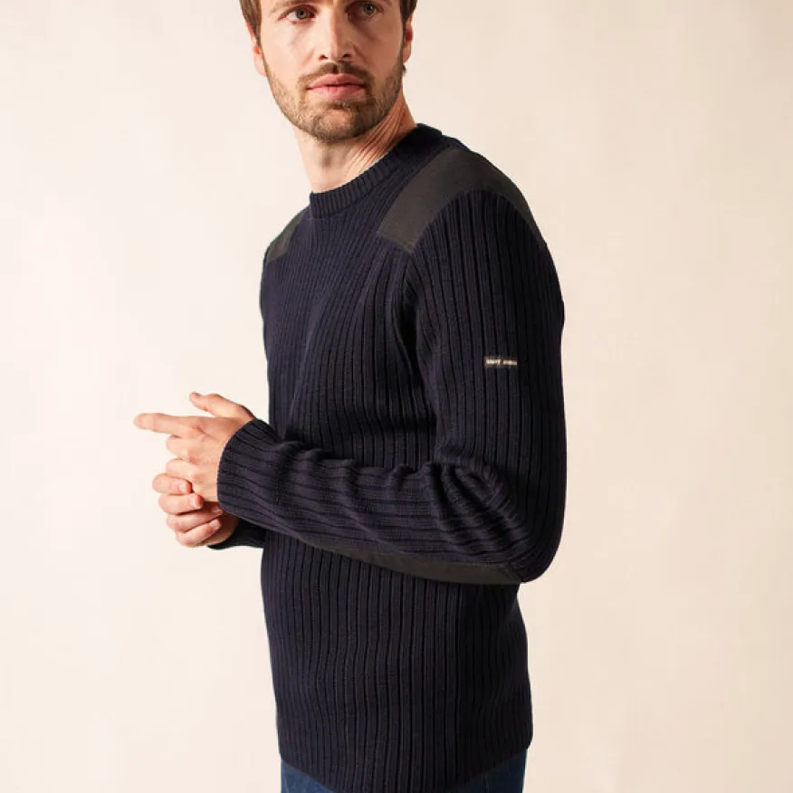 Man wearing a navy blue ribbed sweater with shoulder and elbow patches, looking to the side.
