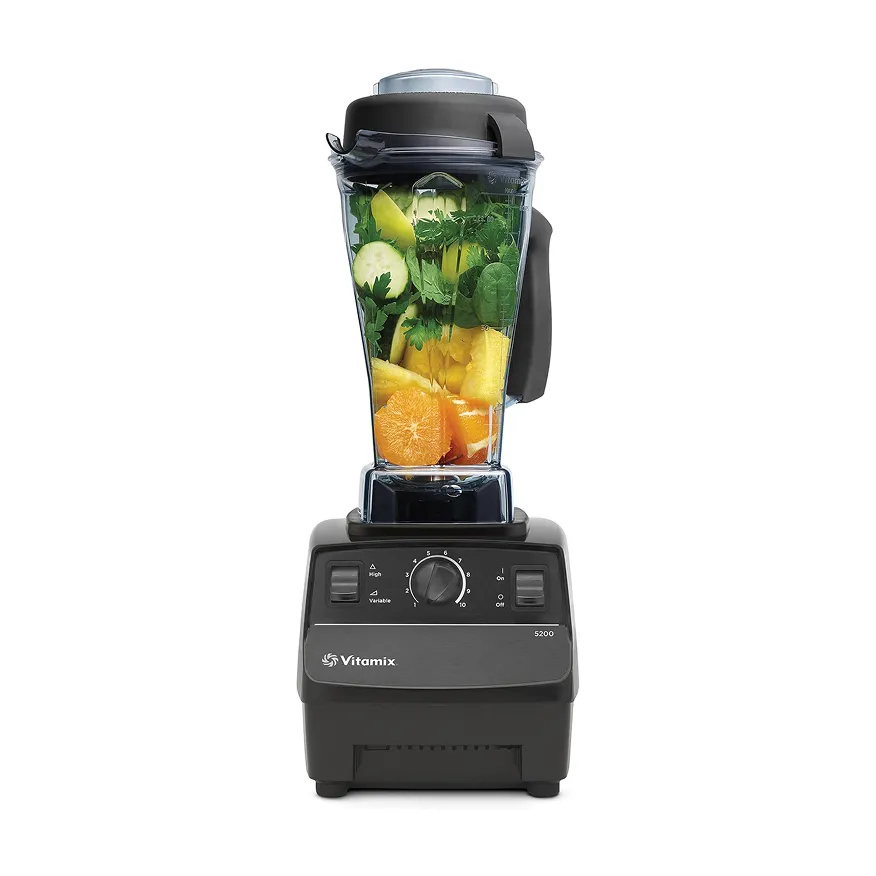 Vitamix 5200 blender filled with fresh fruit and leafy greens.